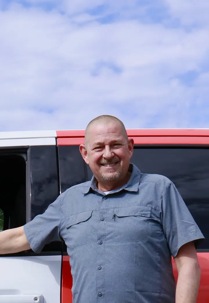 A technician from Les Portes JPR, standing in front of a service truck