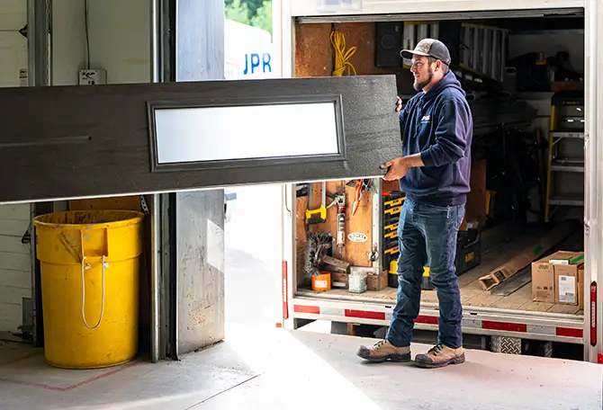 Technicien avec une porte de garage dans son camion